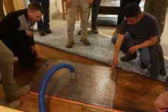 property restoration students removing water from subfloor